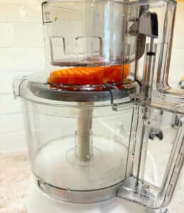 Carrots in the top of the food processor before shredding.