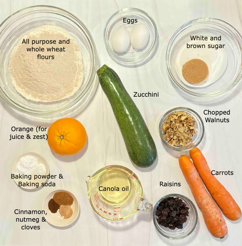 Ingredients to make zucchini carrot bread on a marble counter