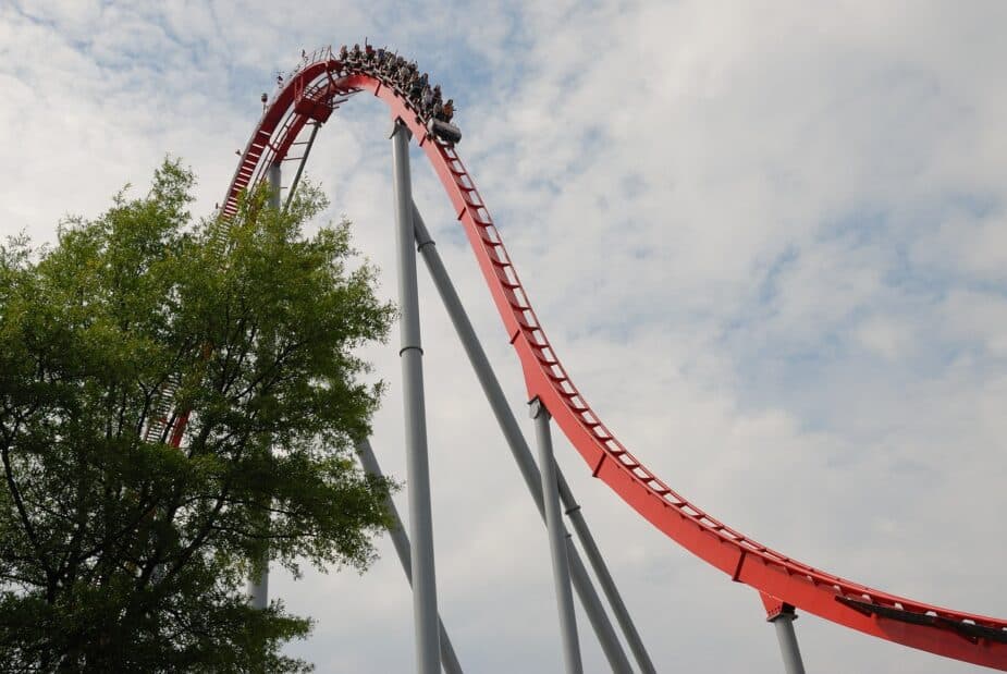 A roller coaster with the cars at the top of a steep hill