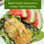 3 baked falafels on top of mixed greens with a drizzle of tahini dressing. Watermelon slices are on the side