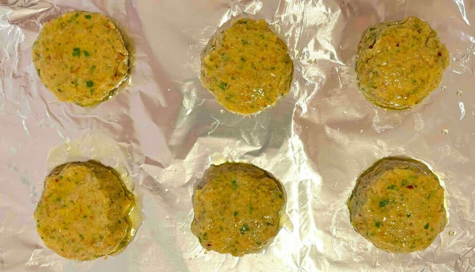 6 falafel patties brushed with oil on a foil lined pan before baking