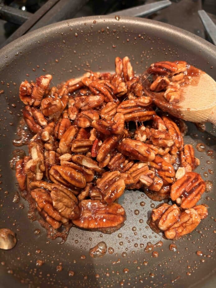 Pecans tossed in hot maple syrup.