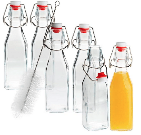 6 clear glass bottles with attached tops that swing and lock into place. A bottle brush is also pictured.