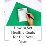 A person writing in a blank journal with the title "How to Set Healthy Goals for the New Year" right below.