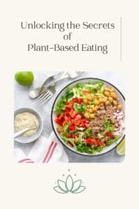 A salad bowl filled with plant based foods on a white table.