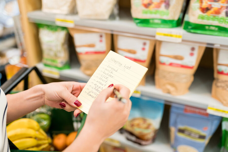 A woman shopping from a list is one of many plant based meal prep ideas